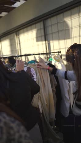 Flea-market,-vintage-woman-clothes-selection-fashion-shopping,-vertical-video