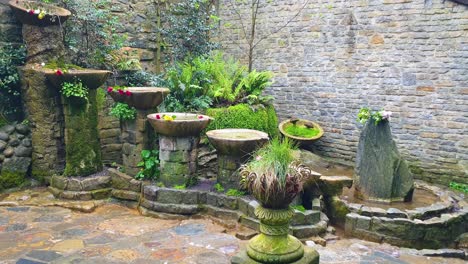 View-of-the-Chalice-Well-aka-Red-Spring-natural-water-spring-flowing-through-idyllic-garden-at-foot-of-Glastonbury-Tor-in-Somerset,-England-UK