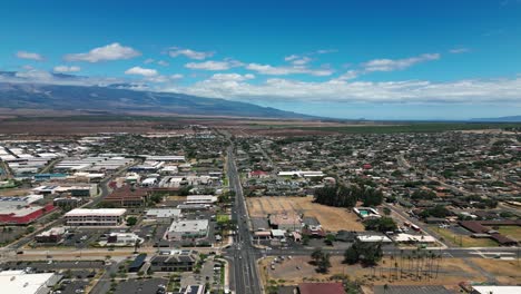 Drone-orbiting-to-reveal-Kahului-cityscape-with-Mount-Haleakala-in-background-summer-blue-sky-hawaii-maui