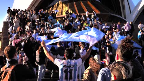 Close-shot-of-Argentina-soccer-fans-celebrating-the-16th-Copa-America-win-on-the-steps-of-the-Opera-House,-Sydney,-Australia