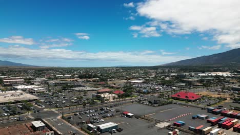 Drone-flies-over-Kahului-Maui-cityscape-with-mountains-and-blue-sky-in-summer