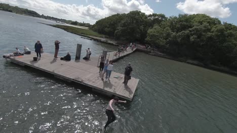 Kinoreifes-Video-Eines-Jungen-Und-Fitten-Mannes,-Der-An-Einem-Heißen-Und-Sonnigen-Tag-An-Der-Südküste-Englands-Ins-Wasser-Springt