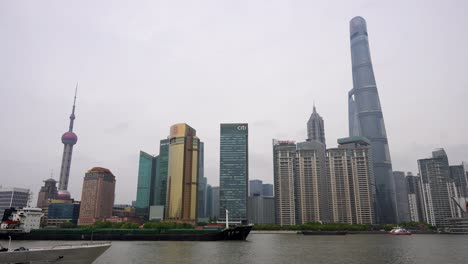 Long-cargo-ship-navigating-Huangpu-River-in-front-of-Lujiazui-financial-district