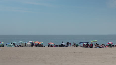 Coney-Island-beach-in-the-summer,-people-relaxing-on-soft-sand,-New-York-US