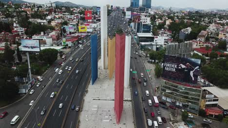 Slow-motion-overhead-shot-of-the-Satélite-towers-and-the-lanes-surrounding-it,-a-cloudy-midday-in-the-suburbs-of-Mexico-City