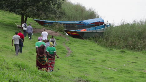 Ugander-Zu-Fuß-Zu-Den-Booten,-Die-Am-Flussufer-In-Kampala,-Uganda-Vertäut-Sind