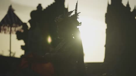 Silueta-De-Una-Bailarina-Balinesa-Actuando-Al-Atardecer-Con-Atuendo-Tradicional-Y-Telón-De-Fondo-Del-Templo