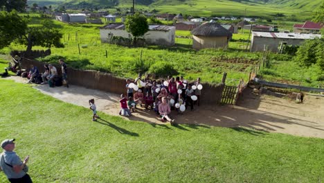 People-interacting-with-locals-in-drakensberg,-south-africa-holding-balloons,-aerial-view