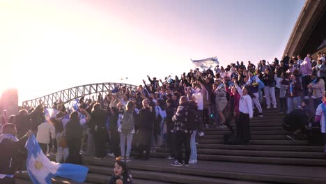 Close-shot-of-Argentina-soccer-fans-celebrating-the-16th-Copa-America-win-on-the-steps-of-the-Opera-House,-Sydney,-Australia