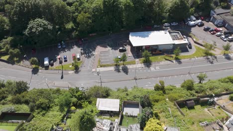 Aerial-fly-in-of-KFC-fast-food-drive-through-restaurant-with-adjacent-roads-and-parking-in-Plymouth,-UK