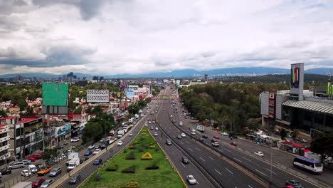 Drone-view-towards-the-Mexico-City-skyline-seen-from-the-Cuidad-Satélite-slope,-in-the-suburbs