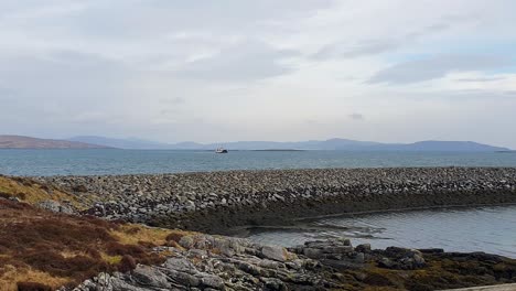 Inter-island-ferry-arriving-from-Eriskay-to-Barra-to-collect-cars-and-passengers-on-the-remote-Outer-Hebrides-isles-in-Scotland-UK