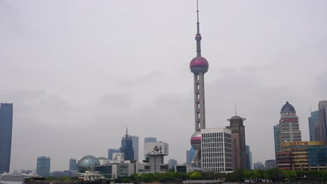 Oriental-Pearl-Tower-standing-out-in-Shanghai-Lujiazui-financial-district-skyline-with-gray-sky,-China