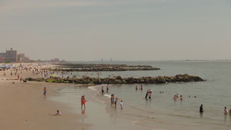 La-Gente-Disfruta-Del-Océano-Atlántico-Norte-En-La-Playa-De-Coney-Island-En-Nueva-York,-EE.UU.