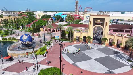 Universal-Studios-Orlando-entrance-with-globe-fountain,-palm-trees,-and-roller-coaster-in-background