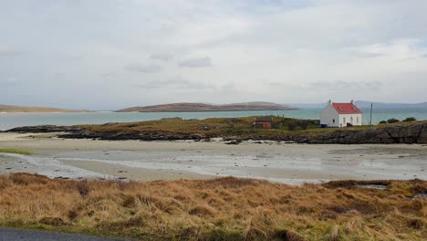 Scenic-coastal-view-of-remote-house-on-croft-farmland-overlooking-ocean-on-remote-islands-in-Outer-Hebrides-of-Scotland-UK