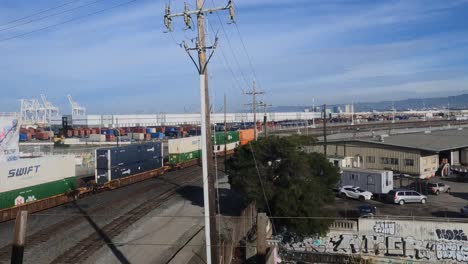 Freight-Train-and-International-Container-Terminal-in-Oakland-Harbor,-California-USA,-View-From-Moving-Metro-Train