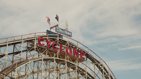 Luna-Park-Cyclone-funfair-ride-with-waving-US-flags,-Coney-Island-in-New-York,-USA