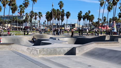 Skateboarders-skating-at-skatepark-of-venice-beach-on-a-sunny-day,-slow-motion