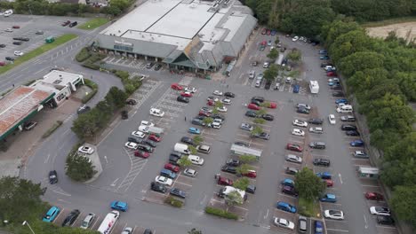 Aerial-orbital-view-of-Morrisons-supermarket-with-extensive-carpark-and-surrounding-infrastructure,-Bude,-Cornwall,-UK,-July-2024