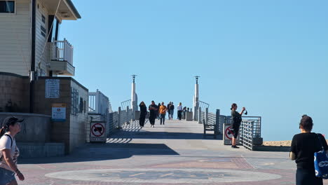 Menschen,-Die-An-Einem-Sonnigen-Tag-Auf-Der-Promenade-Von-Manhattan-Beach-Spazieren-Gehen