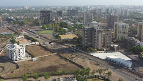 Desde-Arriba,-Muchos-Vehículos-Circulan-Por-La-Carretera-Y-Los-Edificios-De-Gran-Altura-Se-Encuentran-Detrás-De-Ella.