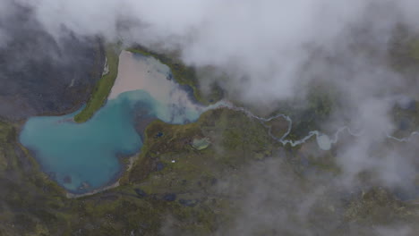 Luftaufnahmen-Von-Oben,-Die-Langsam-über-Den-Wolken-Eines-Wunderschönen-Grün-blauen-Sees-Und-Bachs-In-Ausangate,-Peru-Aufsteigen