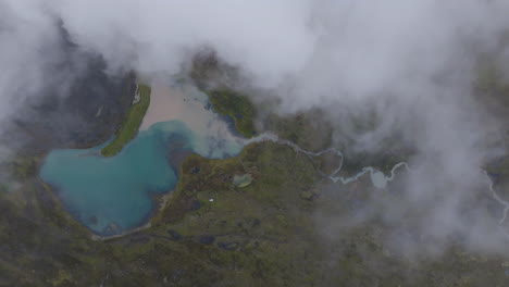 Luftaufnahmen-Von-Oben-über-Den-Wolken-Eines-Wunderschönen-Grün-blauen-Sees-Und-Bachs-In-Ausangate,-Peru