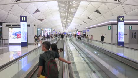 Flight-passengers-are-seen-on-a-moving-horizontal-escalator-heading-to-their-gates-at-the-departure-terminal-of-Chek-Lap-Kok-Hong-Kong-International-Airport