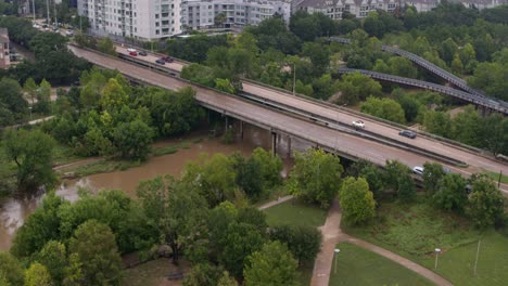 Drone-view-of-cars-traveling-on-bridge-over-the-Buffalo-Bayou-in-Houston,-Texas