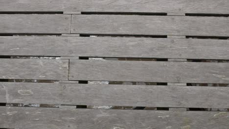 Waves-of-the-sea-under-the-wooden-boards-of-the-pier-walkway-at-the-ocean