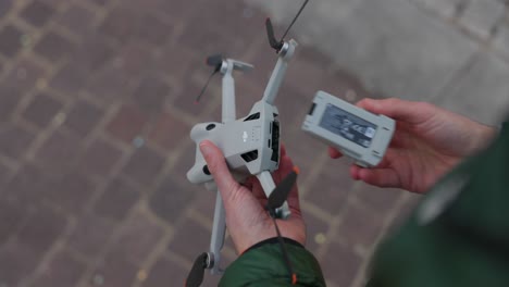 Close-up-of-hands-holding-a-drone-and-inserting-the-battery-outside