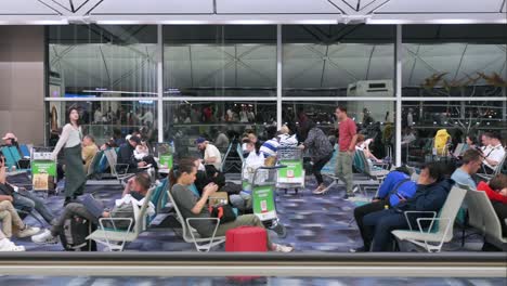 Camera-slider-movement-capturing-flight-passengers-sitting-in-the-waiting-area-at-the-departure-hall-terminal-of-Chek-Lap-Kok-Hong-Kong-International-Airport