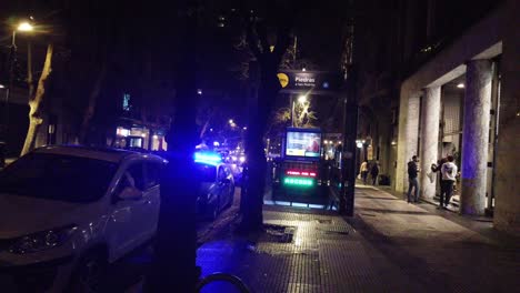 Police-blue-car-lights-shine-at-night-in-metropolitan-gothic-south-american-city