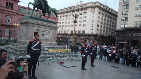 Argentine-people-and-tourists-sightseeing-military-officers-lowering-the-national-Flag-at-Plaza-de-Mayo-with-Pink-house-background