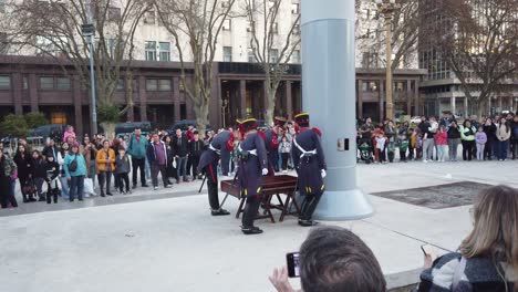 Argentinische-Militäroffiziere-Führen-Eine-Show-Auf-Dem-Zentralen-Städtischen-Platz-Auf,-Während-Touristen-Die-Marschierende-Und-Herabhängende-Nationalflagge-Besichtigen