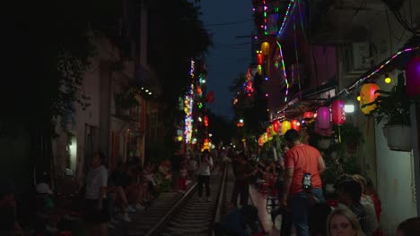 Tourist-attraction-popular-train-street,-people-wait-with-excitement,-slow-motion