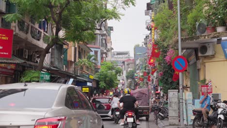 Car-and-motorbike-drive-away-on-a-busy-street-in-the-morning,-slow-motion