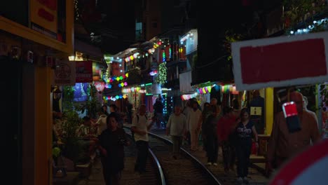 Multitud-De-Turistas-El-Ferrocarril-En-La-Famosa-Calle-Del-Tren-Por-La-Noche,-Luz-Colorida