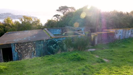 Bunker-Aus-Dem-2.-Weltkrieg-Mit-Graffiti-Und-Sonnenlicht-Mit-Blick-Auf-Den-Hafen-Am-Massey-Memorial-Am-Point-Halswell-In-Wellington,-Neuseeland-Aotearoa