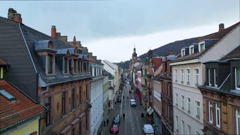 Aerial-zoom-in-inside-Heidelberg,-Baden-Württemberg,-Germany-on-a-rainy-day-drone-view-with-colorful-houses,-windows,-street,-roofs,-cars