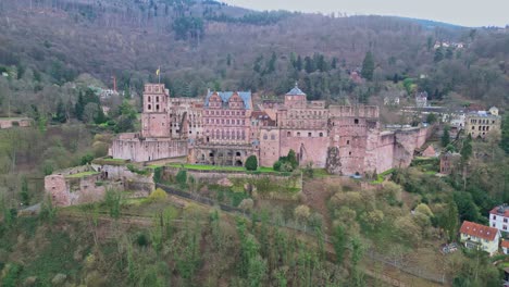 Vista-Aérea-De-Drones-Del-Castillo-Semiórbita-En-Heidelberg,-Baden-Württemberg,-Alemania-Con-Cielo-Nublado