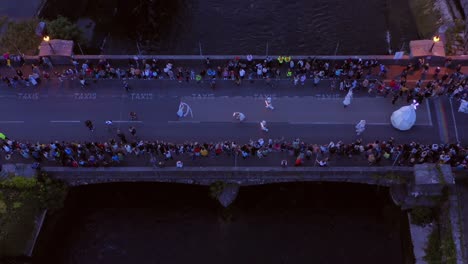 The-Galway-International-Arts-Festival-parade-crosses-O'Brien's-Bridge-at-night