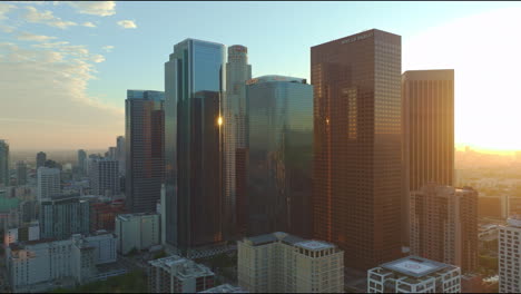 Aerial-view-of-Los-Angeles-high-rises-in-California,-illuminated-by-low-angle-sunshine,-highlighting-the-city's-architectural-splendor