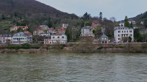 Aerial-parallel-drone-view-panning-to-the-right-of-Heidelberg-houses-city,-Baden-Württemberg,-Germany-with-colorful-houses,-street-and-cars