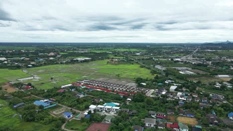 Real-Estate-Housing-Village-Surrounded-by-Rice-Fields-in-Ratchaburi-Province,-Thailand