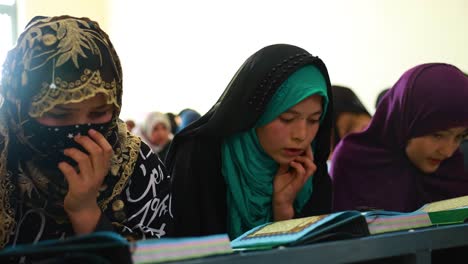 Muslim-Afghan-girls-studying-the-Quran,-a-hijab-wearing-girl,-a-Muslim-girl-in-prayer