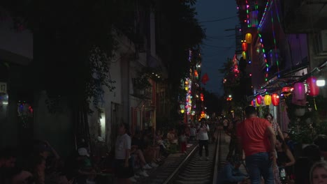 Popular-tourist-attraction-Tran-Phu-train-street,-vibrant-colorful-light-from-cafe