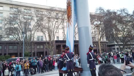 Patriotic-military-officers-lower-Argentine-flat-at-public-act-in-central-Plaza-de-Mayo,-independence-landmark-at-buenos-aires-city