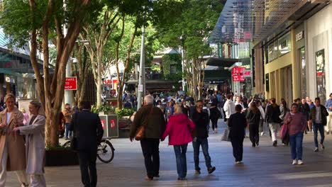 People-shopping-and-dinning-at-Queen-street-mall,-outdoor-pedestrian-shopping-precinct-at-downtown-Brisbane-city,-concept-of-inflation-and-cost-of-living,-slow-motion-shot